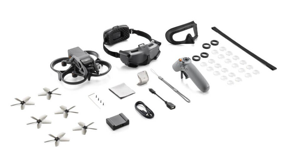 Części i akcesoria drona ułożone na białej powierzchni. Zawiera drona, gogle i kontroler.