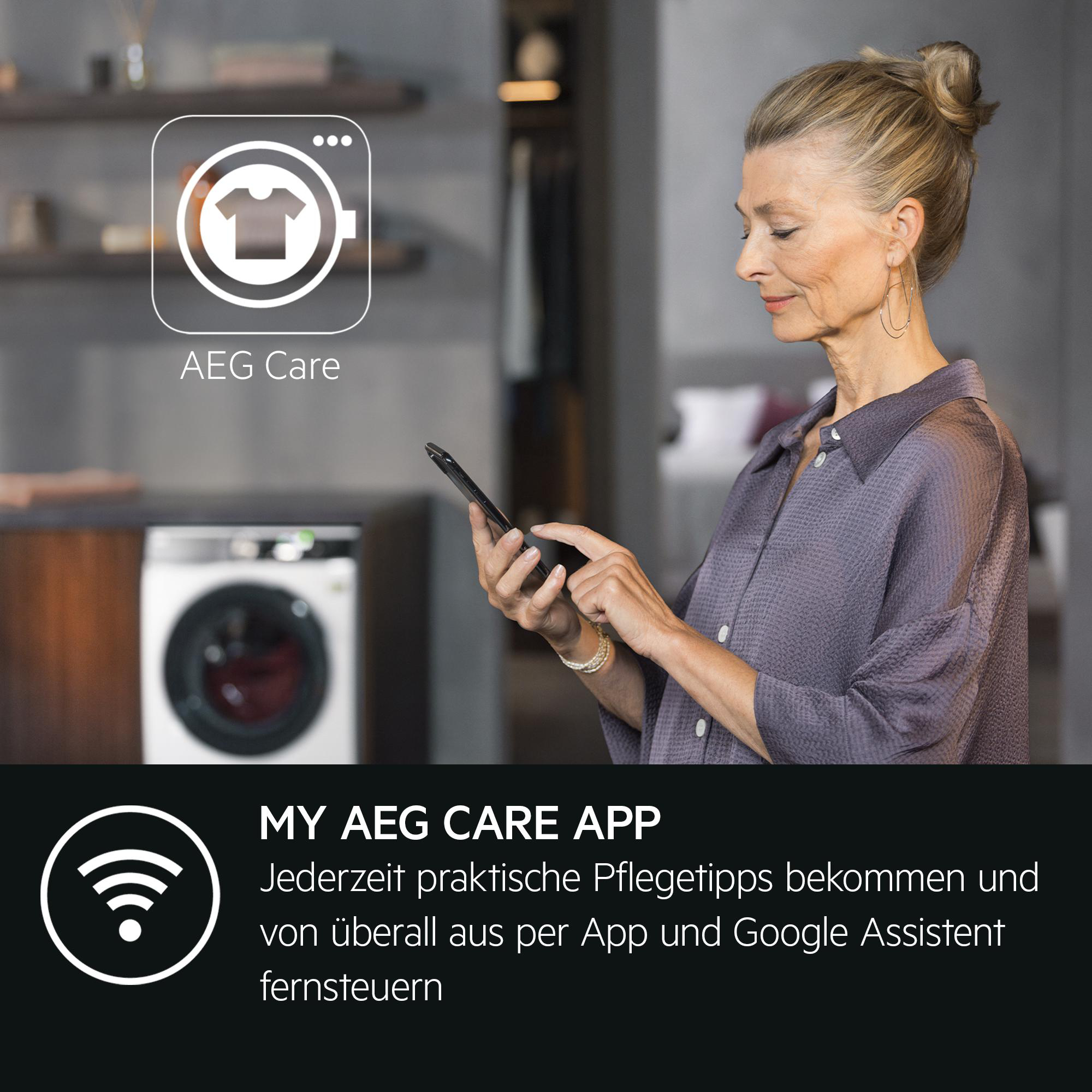 Frau benutzt Handy vor Waschmaschine mit AEG Care App-Symbol.