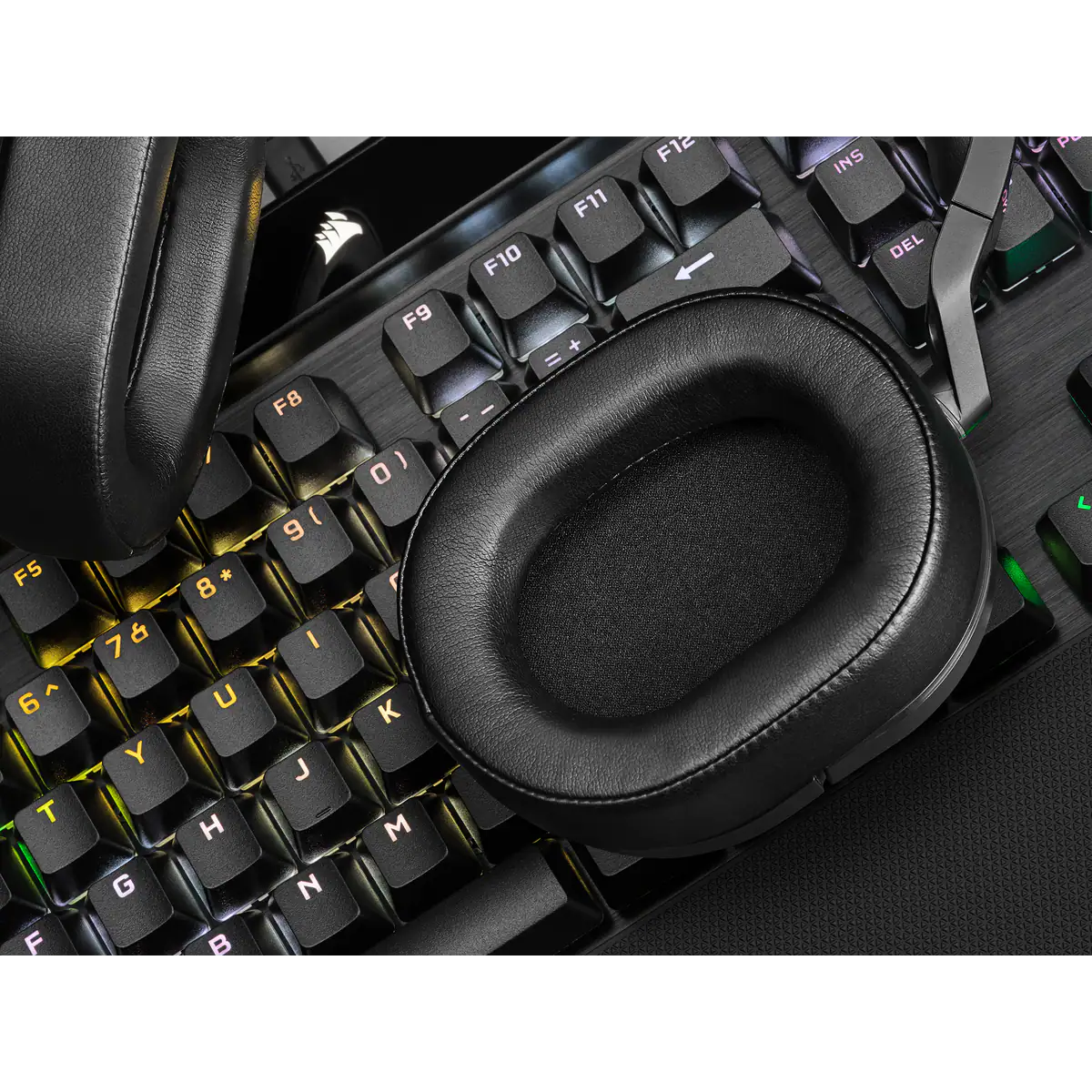 Egy fekete gamer headset a billentyűzeten, fülkagylókat és billentyűket mutatva.