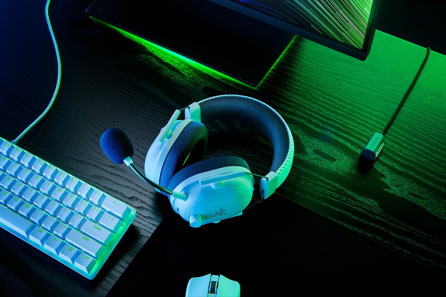 Gaming-Headset mit Mikrofon auf einem Schreibtisch mit Tastatur und anderer Gaming-Ausrüstung.