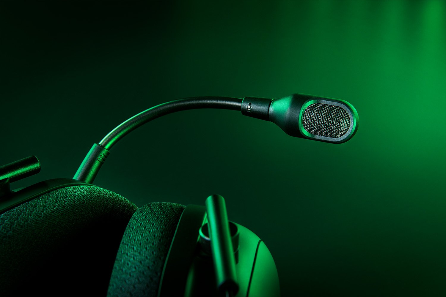 Nahaufnahme eines schwarzen Gaming-Headsets-Mikrofons mit grünem Hintergrundlicht.