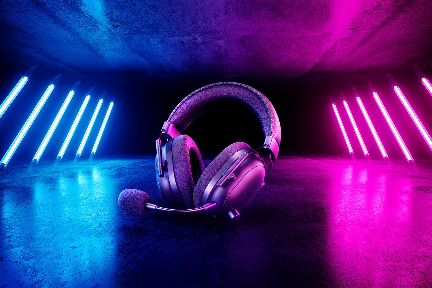 Kopfhörer mit Mikrofon, beleuchtet von blauen und rosa Neonlichtern, auf einer spiegelnden Oberfläche.
