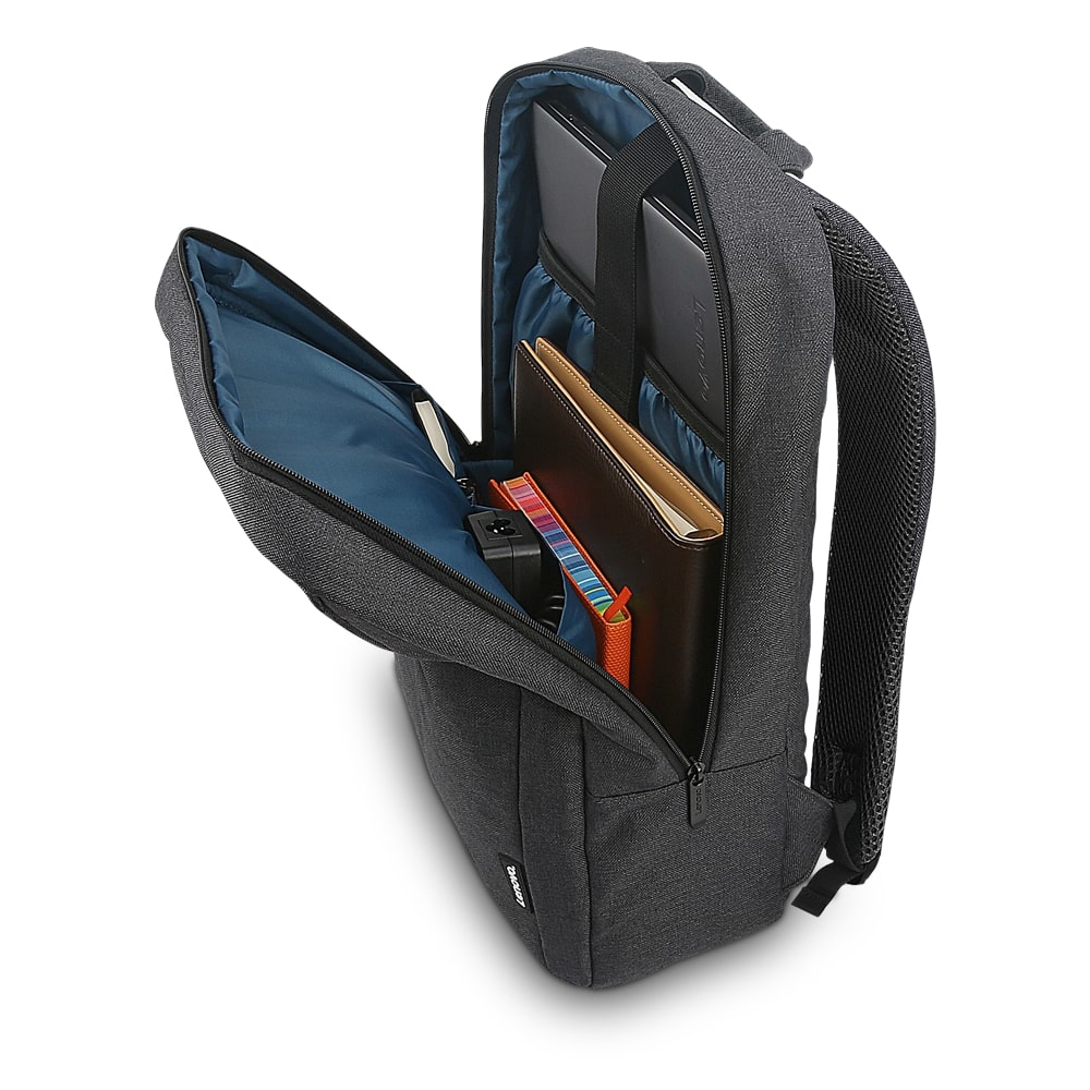 Mochila gris abierta con objetos dentro: portátil, cuaderno, bolígrafo y accesorios. Interior azul.