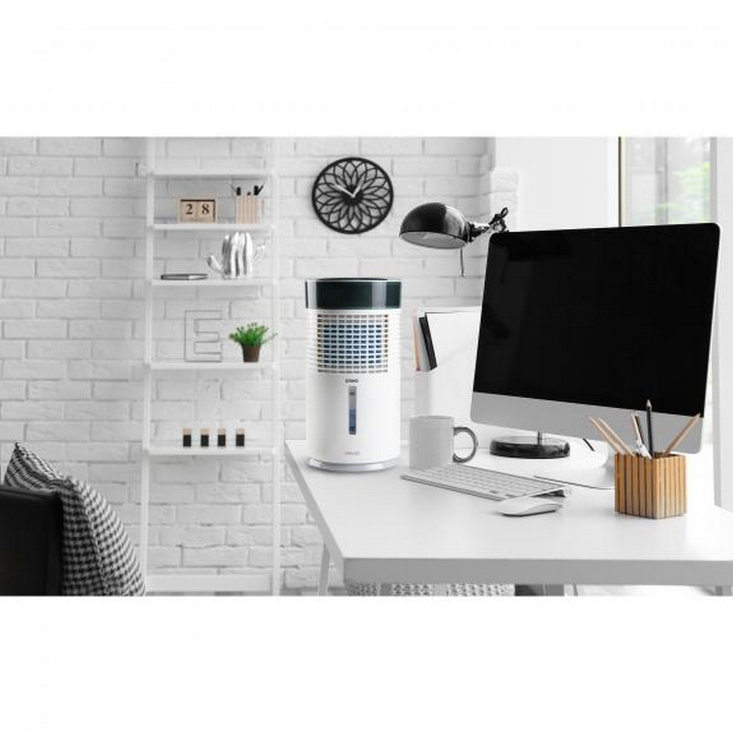 Un purificateur d'air sur un bureau blanc à côté d'un écran d'ordinateur et d'une fenêtre.