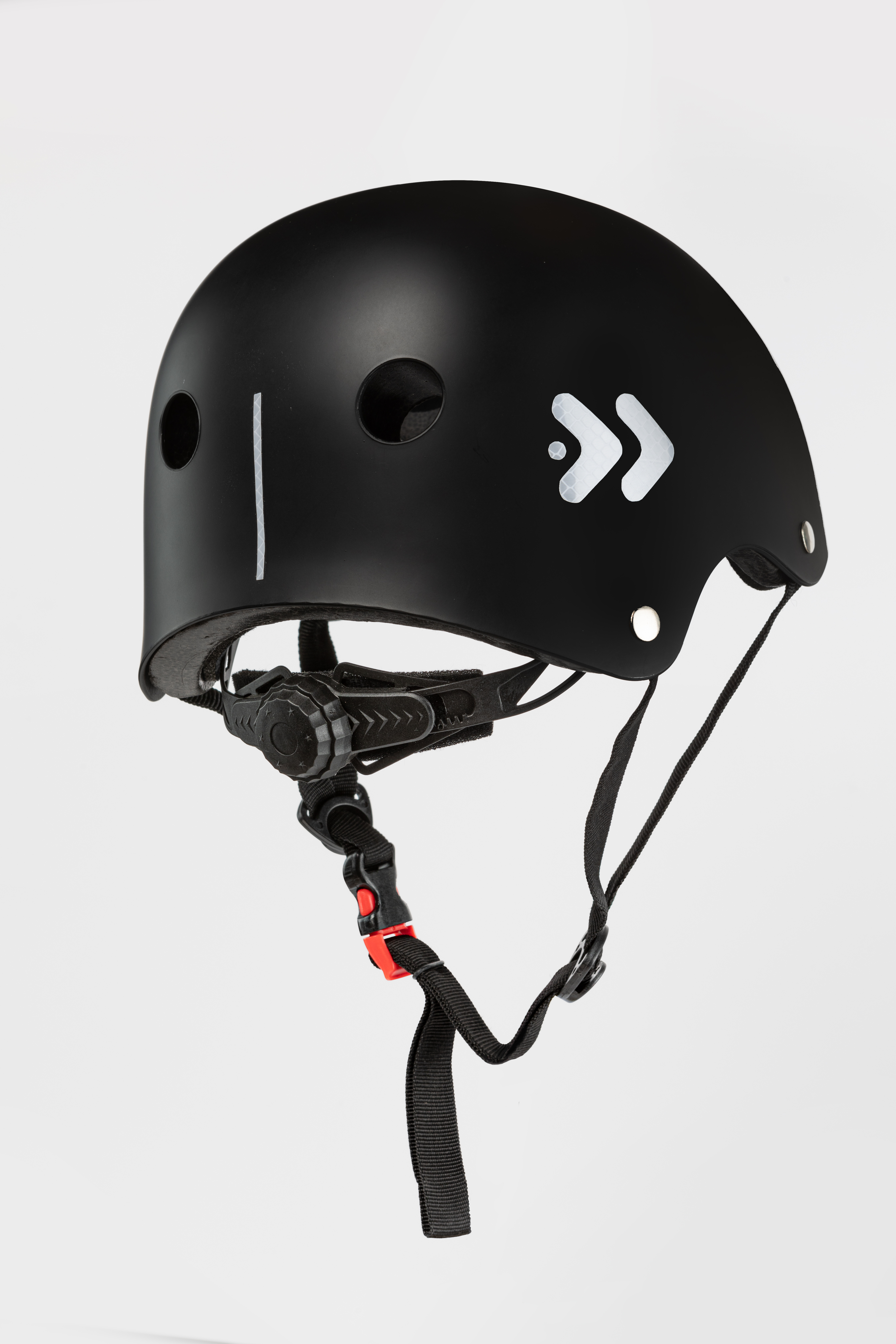 Un casco negro con flechas blancas y una correa. El casco está sobre un fondo blanco liso.