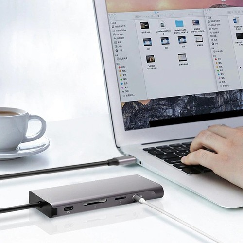 Gri USB hub'a bağlı dizüstü bilgisayar. Sol tarafta bir fincan kahve.
