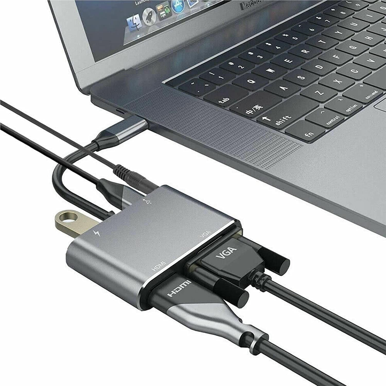 HDMI, VGA ve USB kablolarının takılı olduğu gümüş bir hub'a bağlı dizüstü bilgisayar.