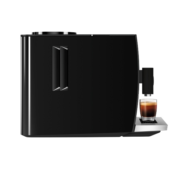 Una cafetera Jura negra con un vaso de espresso a su lado.