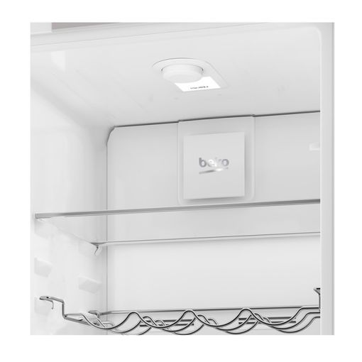 Dentro de un refrigerador blanco. Hay una luz y estantes. El logotipo de Beko es visible.