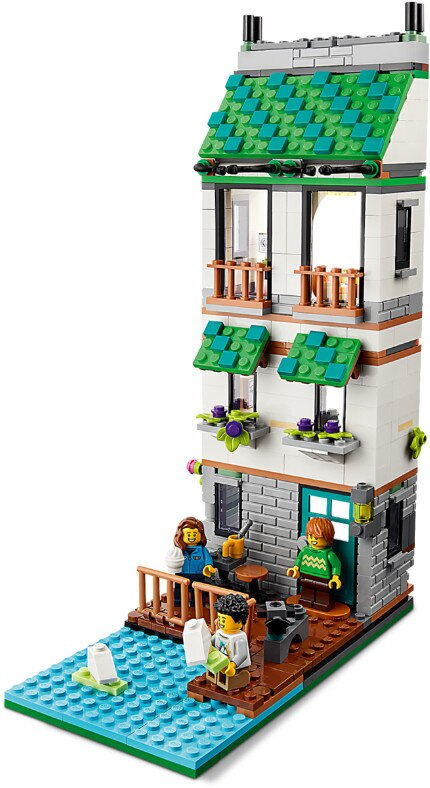 Budynek Lego ze szczegółowymi oknami, balkonami i figurkami. Małe jezioro znajduje się przed budynkiem.