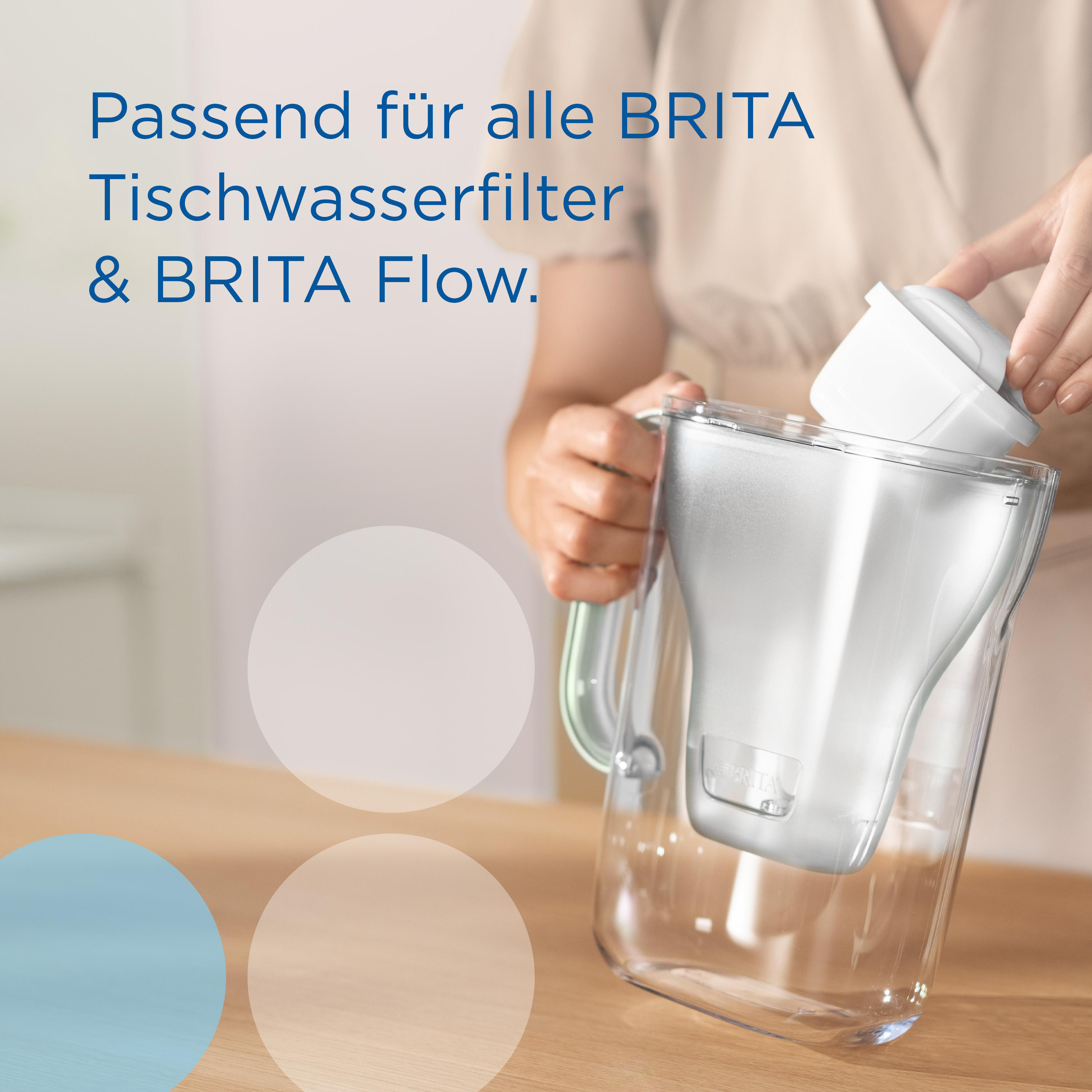 Hände einer Person, die einen Filter in eine Brita-Wasserkanne legen.