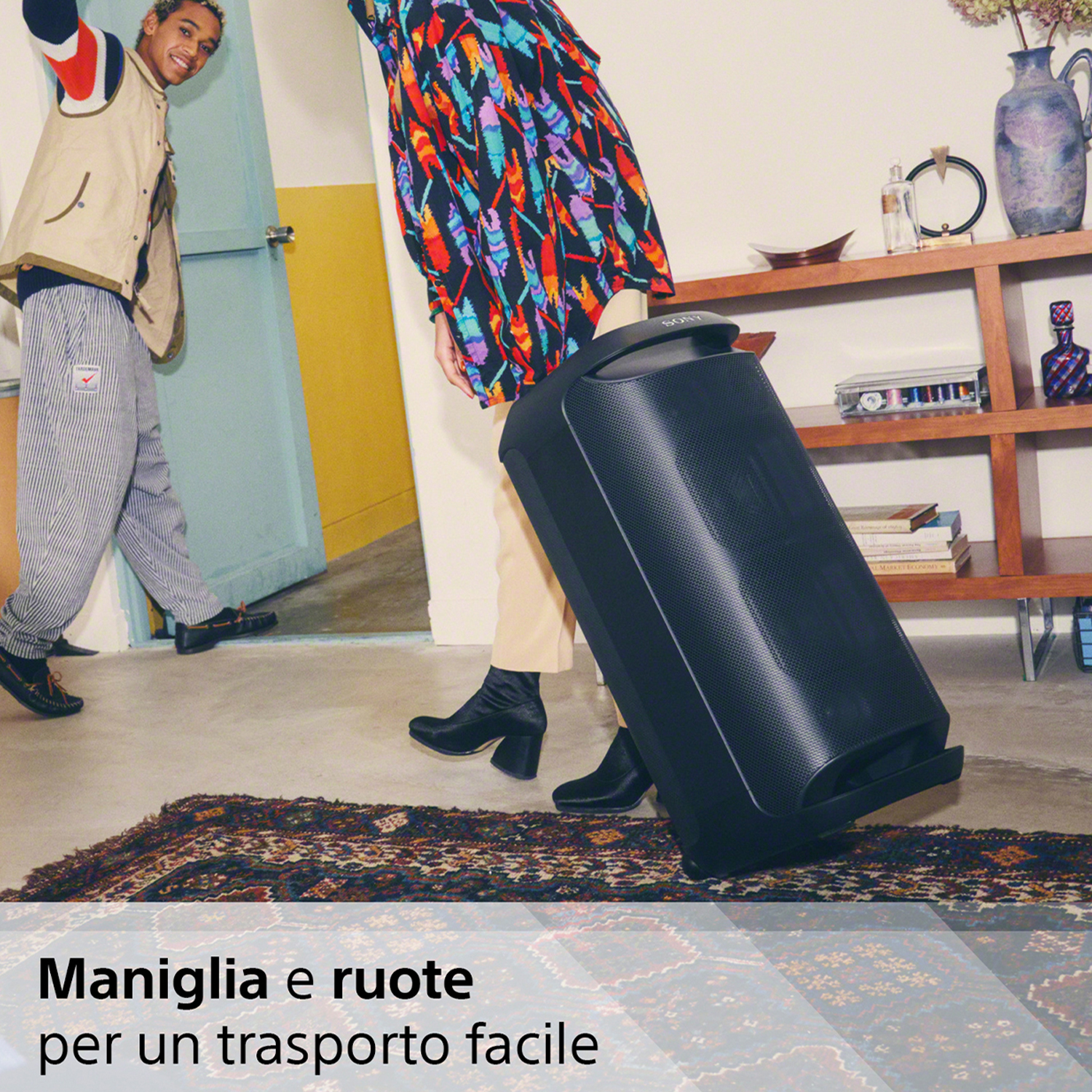 Persone che trasportano un grande altoparlante con maniglia.