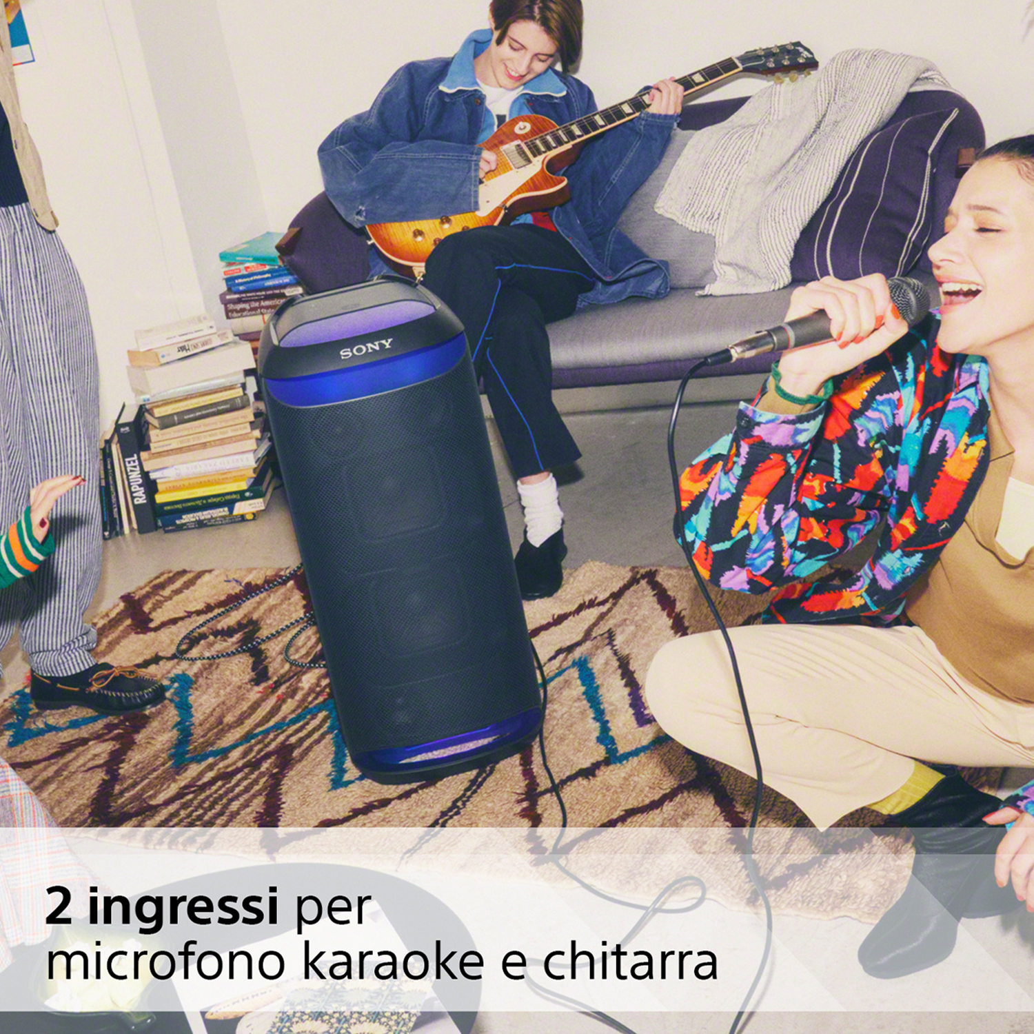 Persone in una stanza con un altoparlante e una chitarra.
