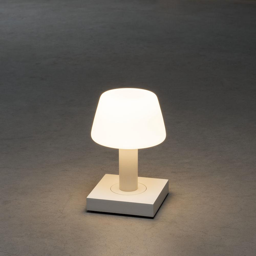 Weiße Lampe mit Licht an. Grauer Hintergrund. Quadratische Basis.