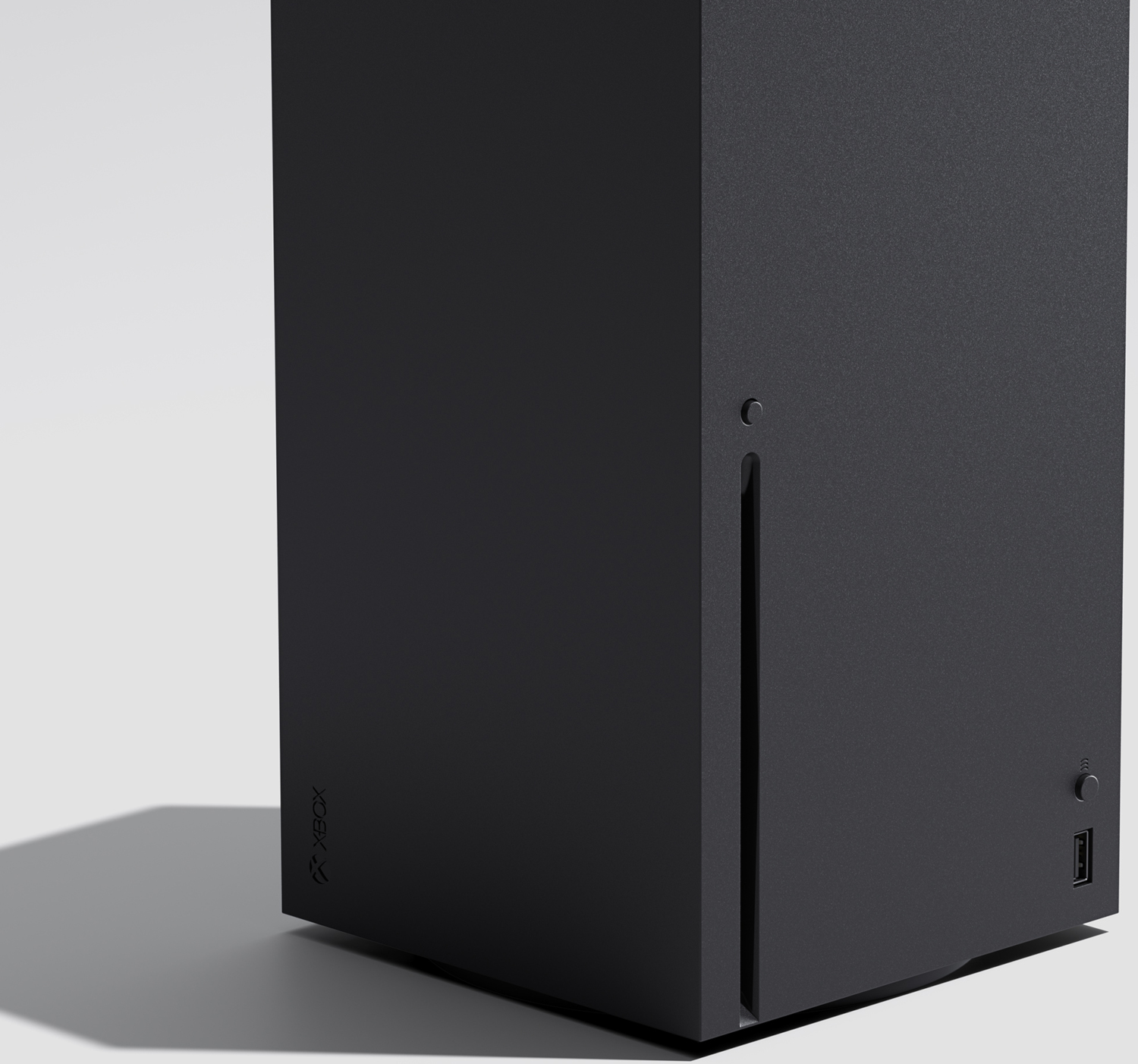 Een zwarte Xbox Series X-console staat op een witte ondergrond. Xbox-logo zichtbaar. Aan/uit-knop en USB-poort aan de zijkant.