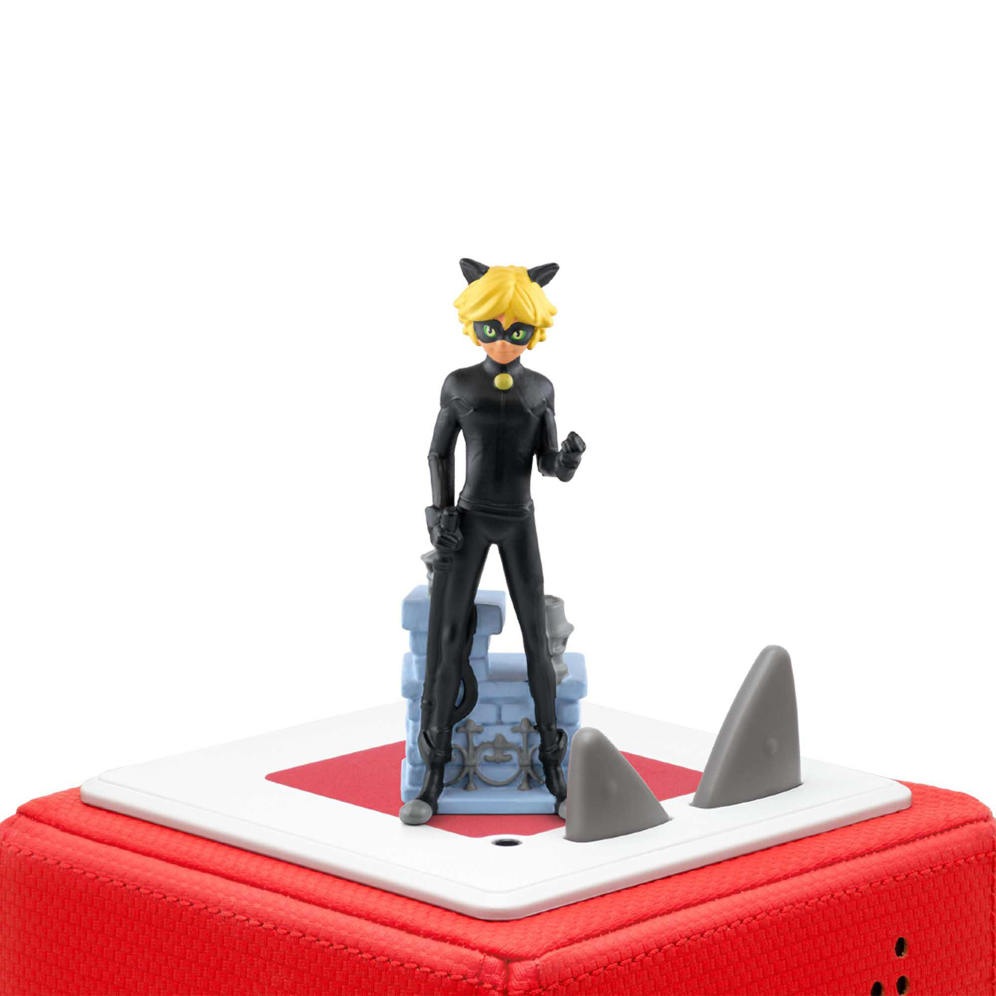 Eine Miraculous Ladybug Figur steht auf einem rot-weißen Würfel mit Haifischflossen.