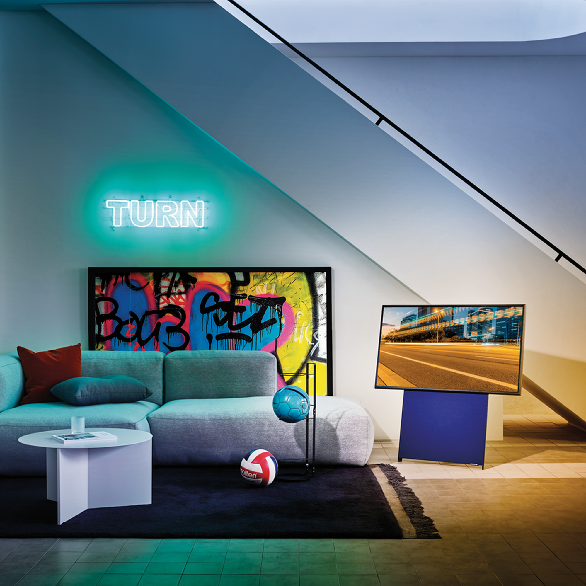 Una sala de estar moderna con un televisor que muestra una vista de la ciudad, un sofá y arte graffiti.