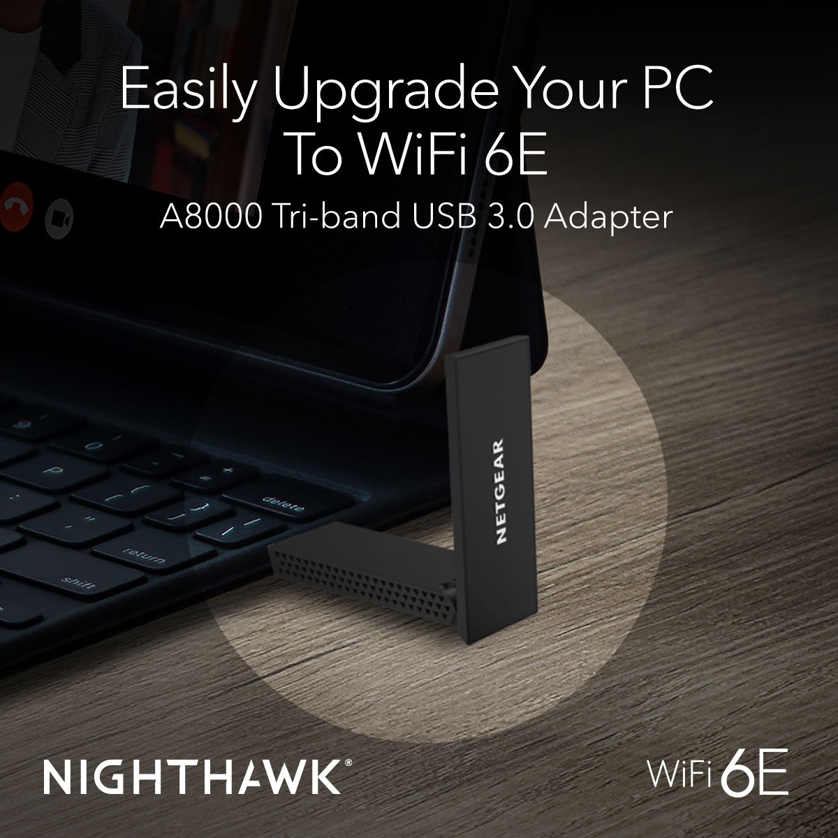 Ein schwarzer Netgear USB-Adapter mit weißem 'NETGEAR'-Logo, an einen Laptop angeschlossen.