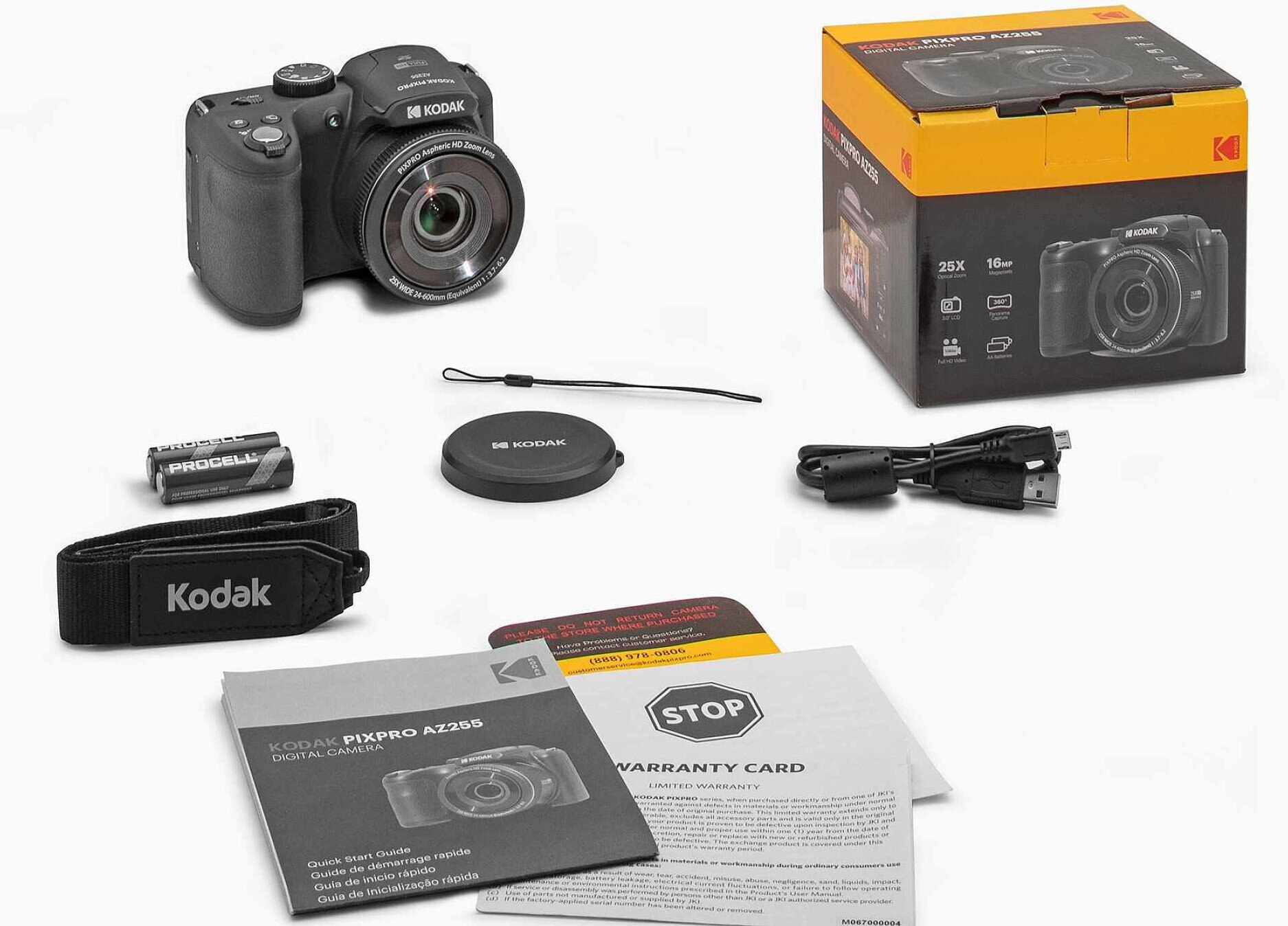 Aparat Kodak Pixpro AZ255S z akcesoriami, w tym bateriami, paskiem, osłoną obiektywu i instrukcjami, na białym tle.