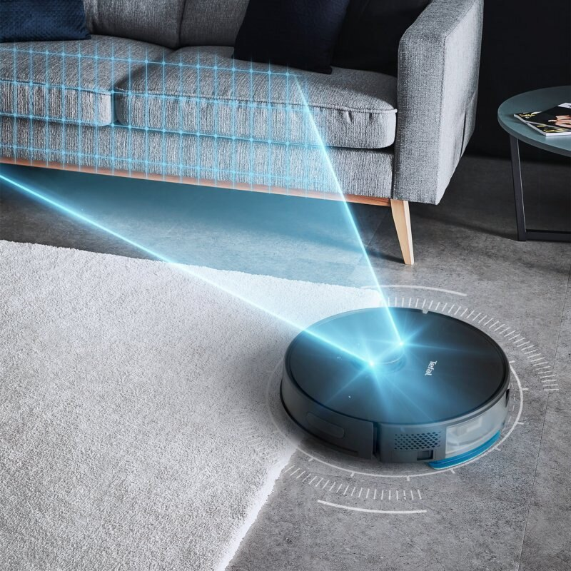 Odkurzacz robot na dywanie, sprzątanie. Sofa w tle.