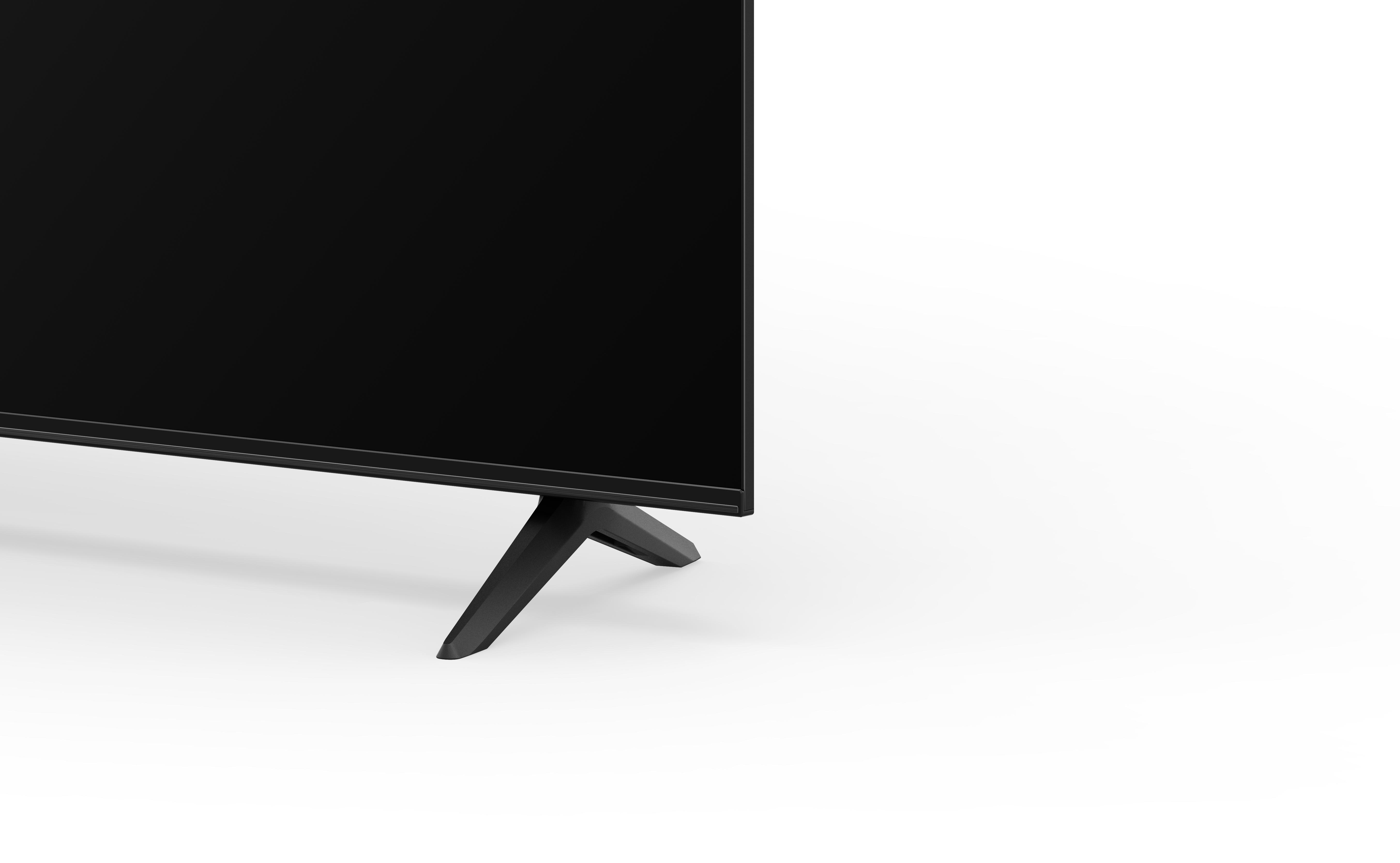 Ein schwarzer Fernseher auf weißem Hintergrund. Nur der Boden und die Beine sind sichtbar.