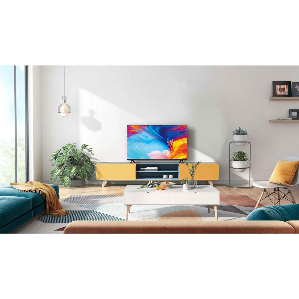 Wohnzimmer mit Fernseher, Sofa, Couchtisch und Dekoration. Gelbe Schränke unter TV.