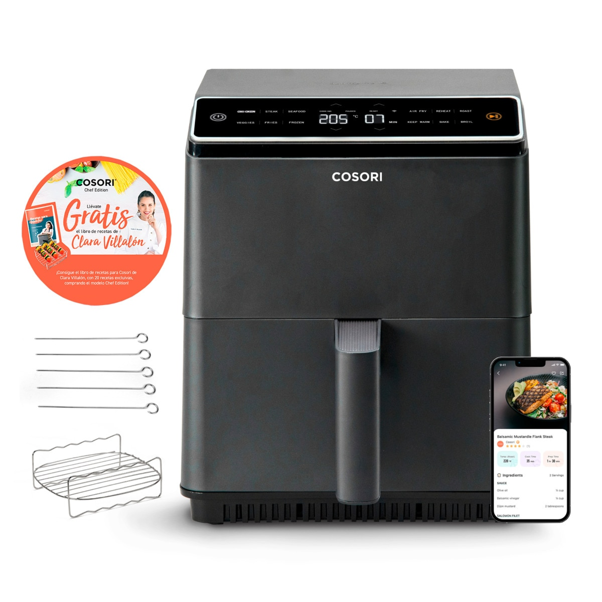 Freidora de aire negra con accesorios, un libro de recetas y un teléfono que muestra una receta.