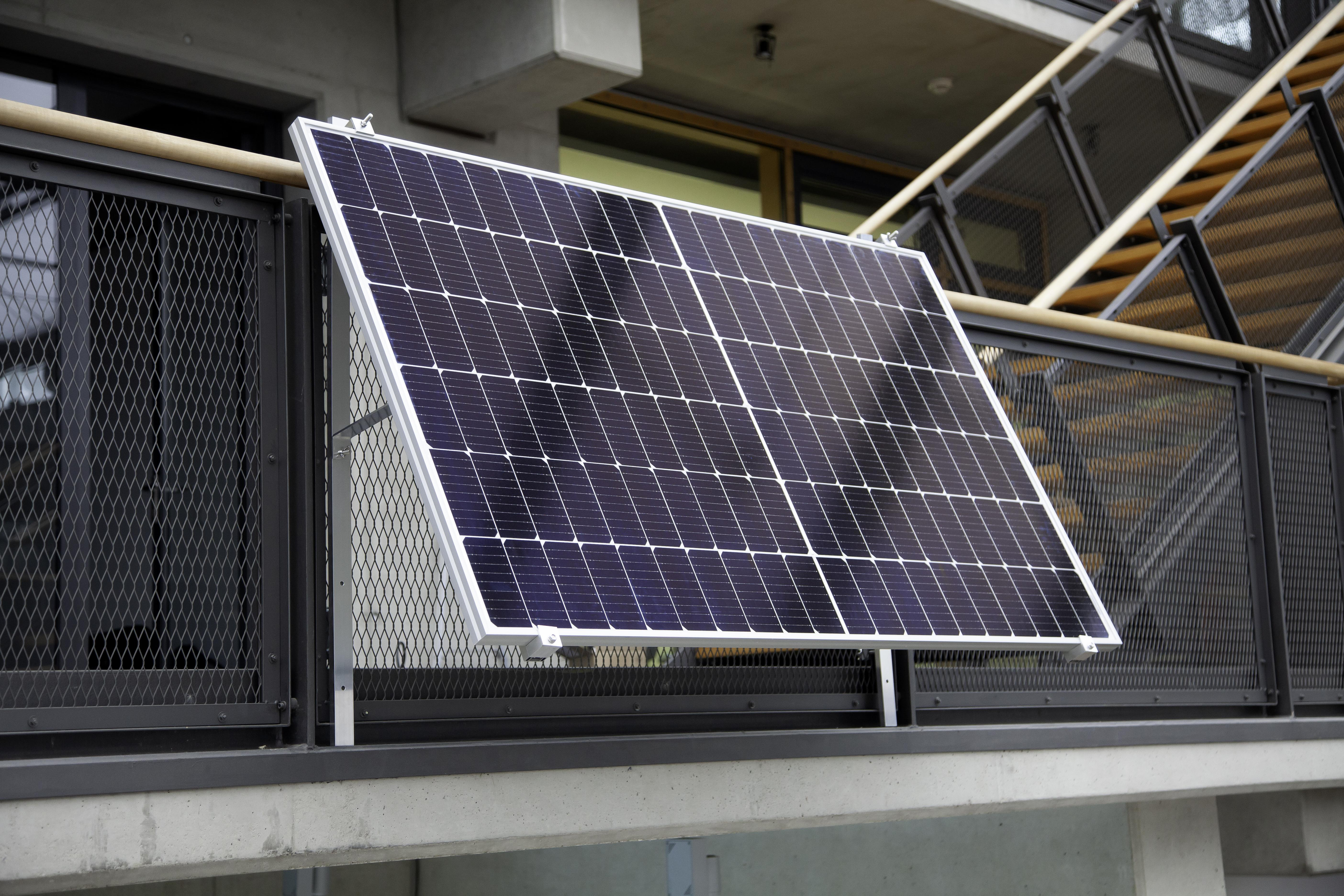 Solarpanel an einem Gebäude. Es ist an einem Geländer befestigt.