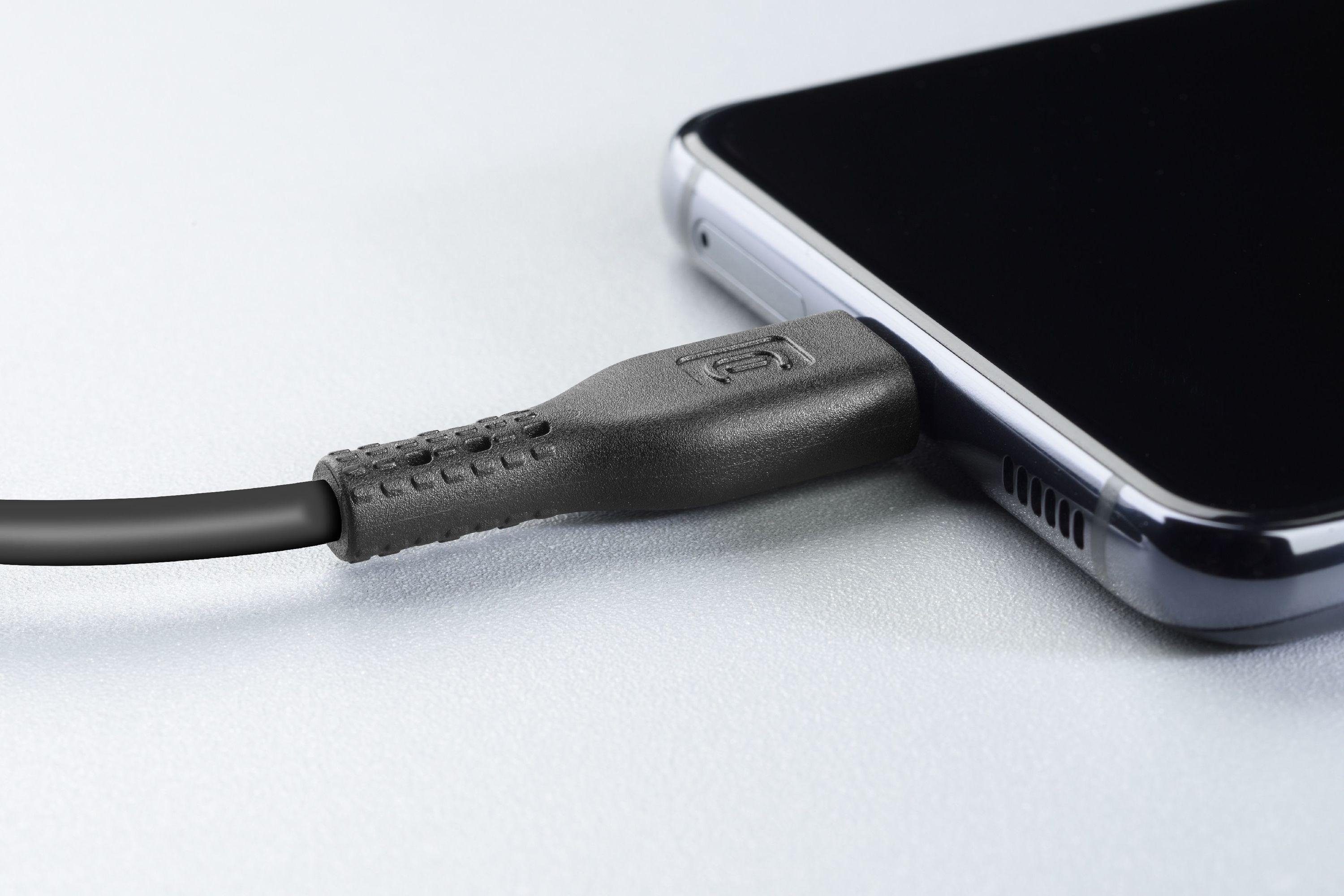 Nahaufnahme eines schwarzen Ladekabels, das in ein schwarzes Smartphone eingesteckt ist.
