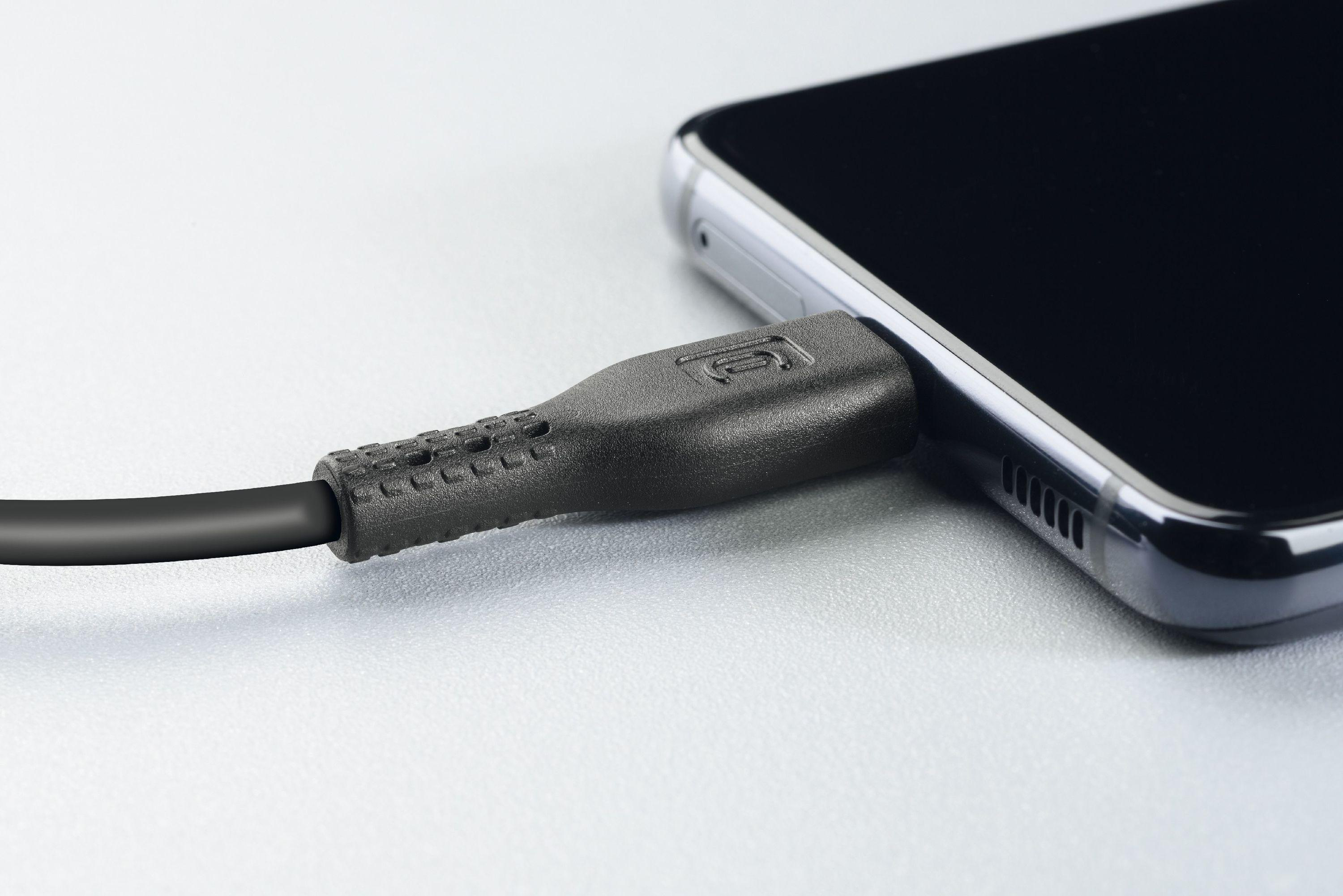 Ein schwarzes Ladekabel ist in ein schwarzes Smartphone eingesteckt.