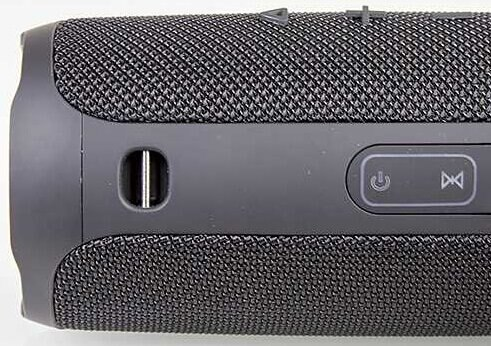 Zbliżenie czarnego głośnika z przyciskiem zasilania i przyciskiem Bluetooth.