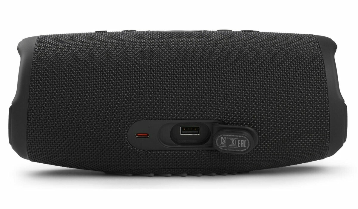 Czarny głośnik JBL, z widocznymi portami, na białym tle, ujęcie z bliska.