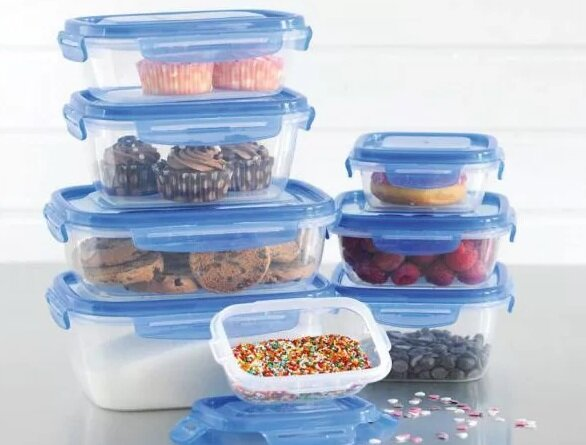 Przezroczyste plastikowe pojemniki na żywność, ułożone w stos, wypełnione różnymi produktami.