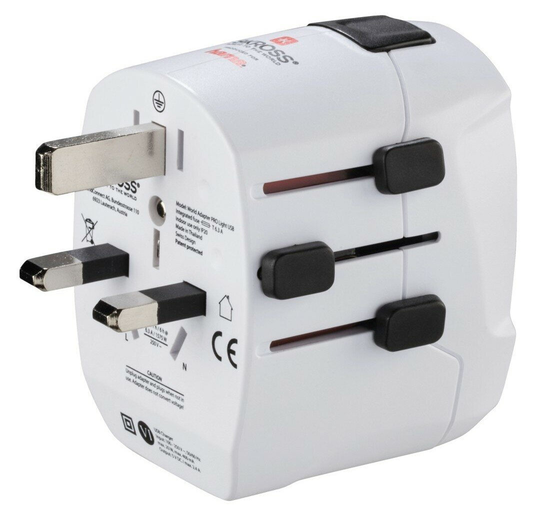 Biała przejściówka podróżna z wieloma konfiguracjami wtyczek i czarnymi suwakami. Posiada port USB i informacje dotyczące bezpieczeństwa.