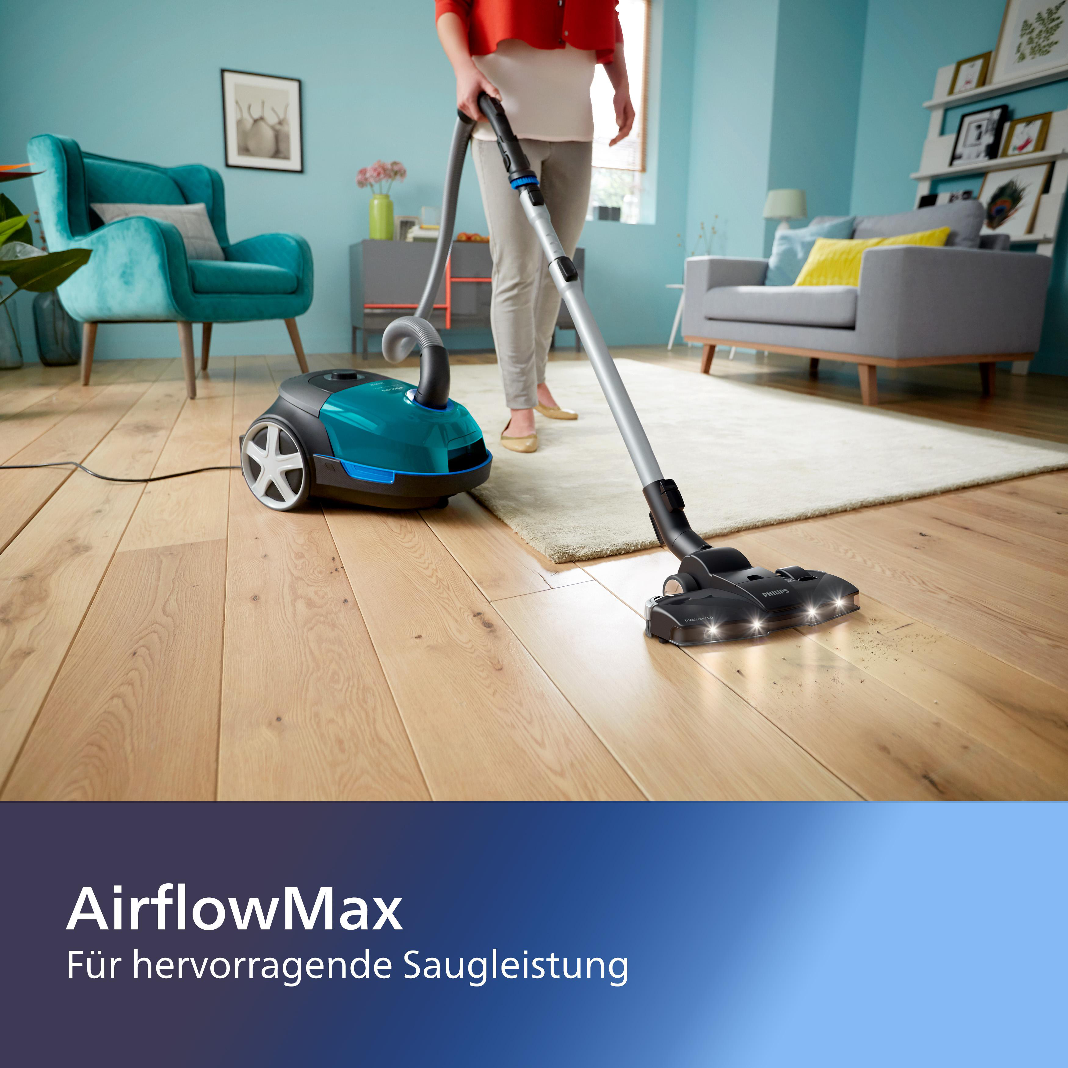 Eine Person saugt einen Holzboden. Ein blauer Staubsauger befindet sich links.