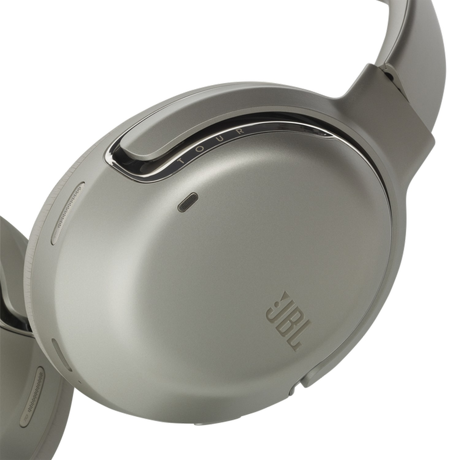 Gros plan sur un casque JBL. L'écouteur est gris avec une bordure argentée et le logo JBL.