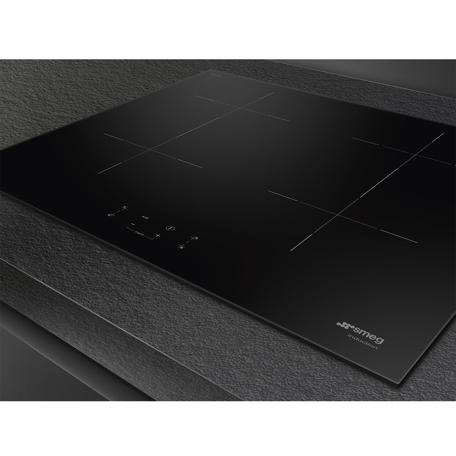 Un piano cottura a induzione nero con sfondo scuro e il logo Smeg.