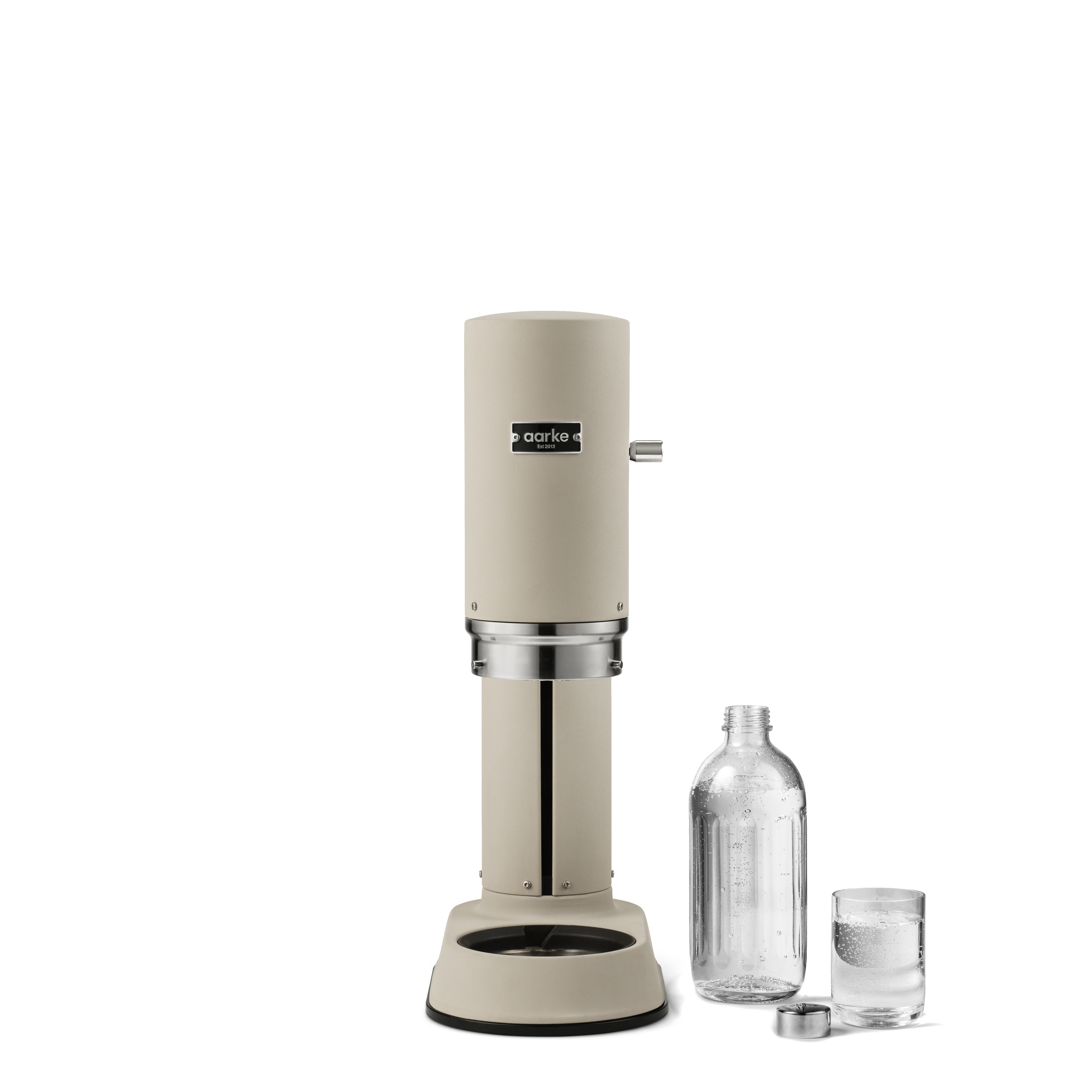 Sodamaker mit Flasche und Glas. Der Maker ist beige und silber.