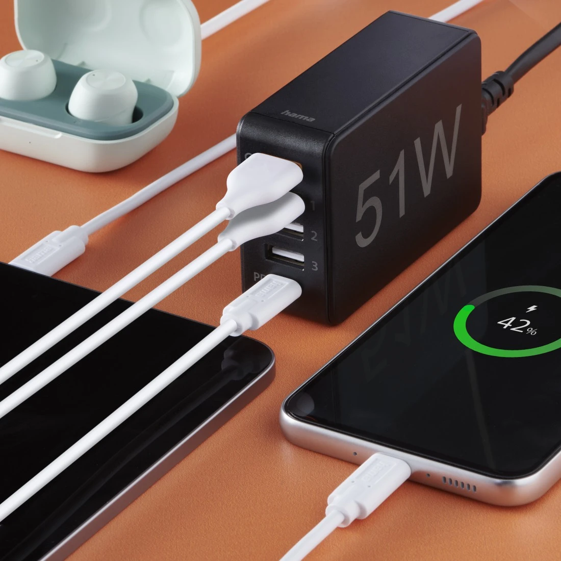 Schwarzes Netzteil mit mehreren USB-Anschlüssen, lädt Geräte auf einem Tisch.