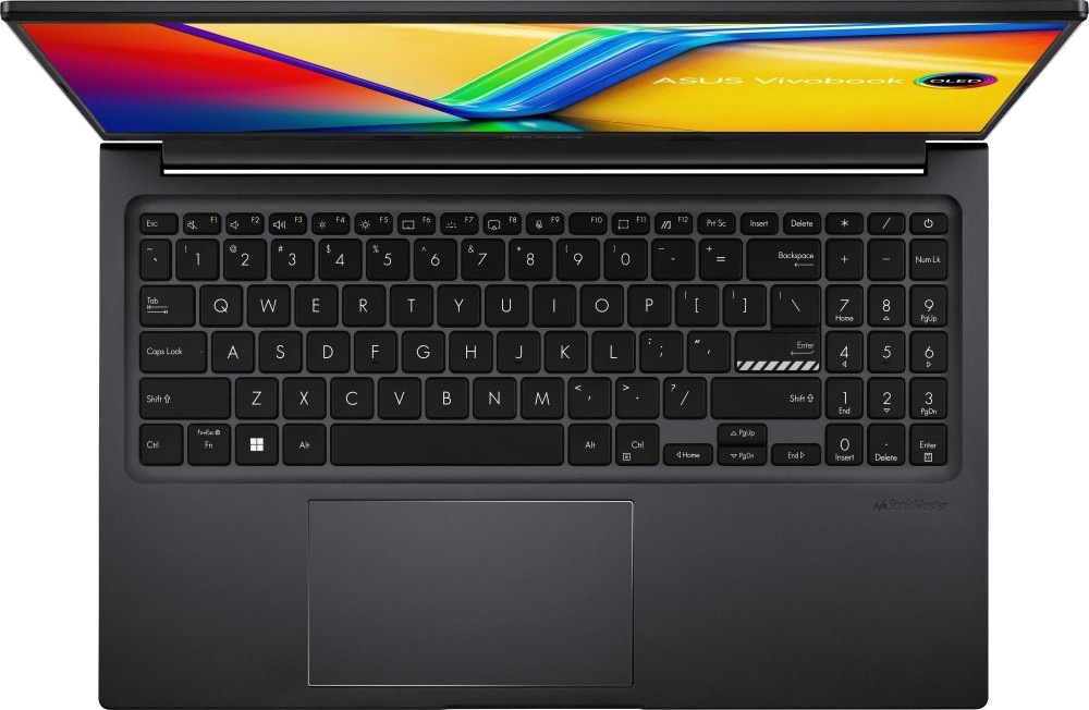 Vue aérienne d'un ordinateur portable noir avec l'écran ouvert. Le clavier est visible, ainsi que le pavé tactile et l'écran couleur.