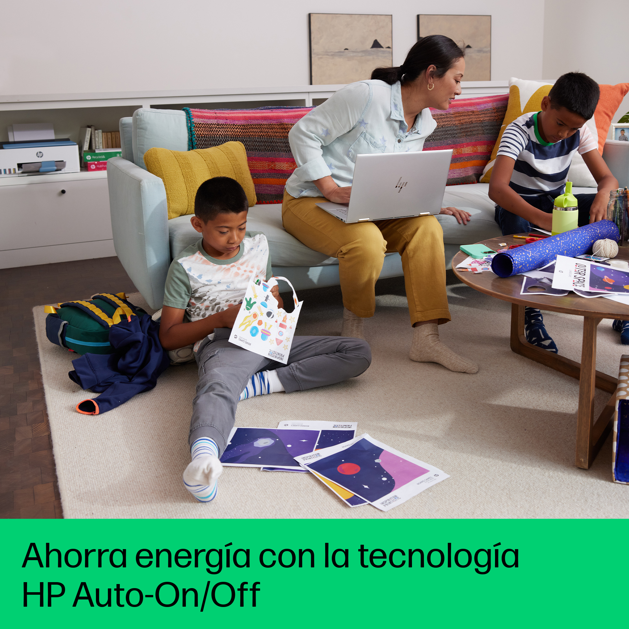 Una familia está reunida alrededor de una mesa, usando una laptop, dibujando y mirando papeles.