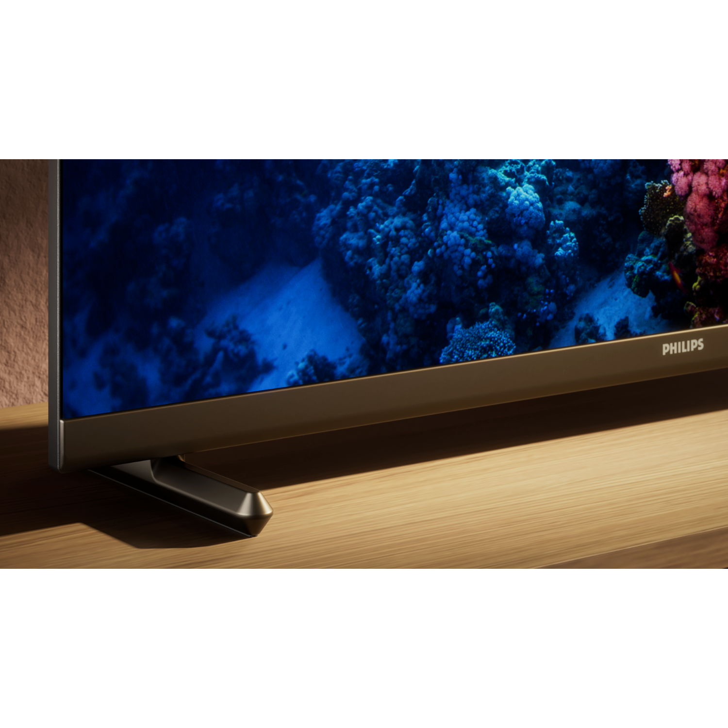 Een tv-scherm met een onderwaterlandschap, op een houten tafel. De tv is een Philips-model.