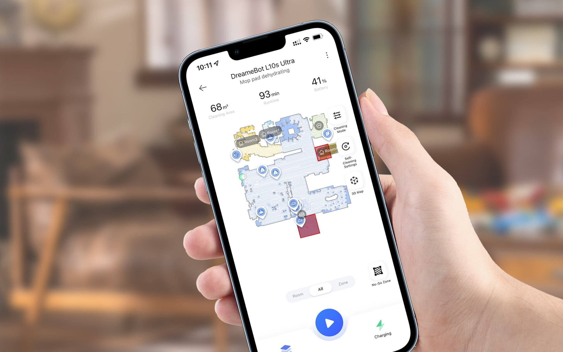 Dłoń trzymająca telefon z mapą pokoju. Telefon wyświetla mapę czyszczenia.