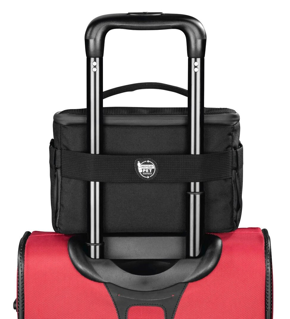 Czarny transporter dla zwierząt na czerwonej walizce. Czarny uchwyt i pasek. Białe tło.