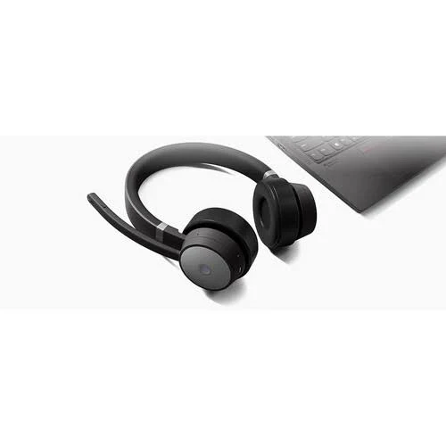Auriculares negros sobre una superficie blanca. Portátil en el fondo.