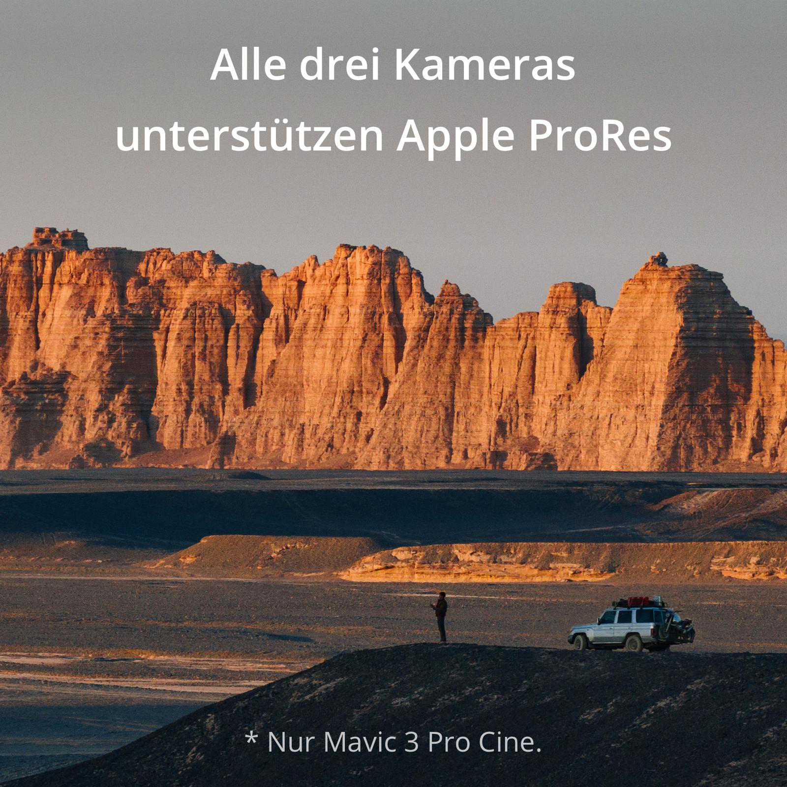 Landschaft mit Bergen bei Sonnenuntergang. Ein weißes Auto und eine Person im Vordergrund.