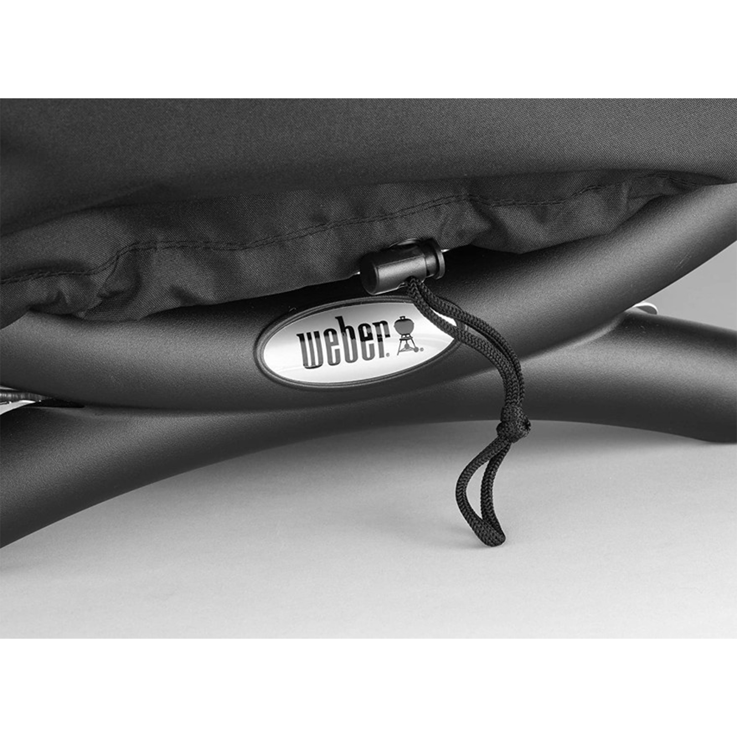 Un telo nero per barbecue con logo Weber. Un cordoncino nero è stretto.