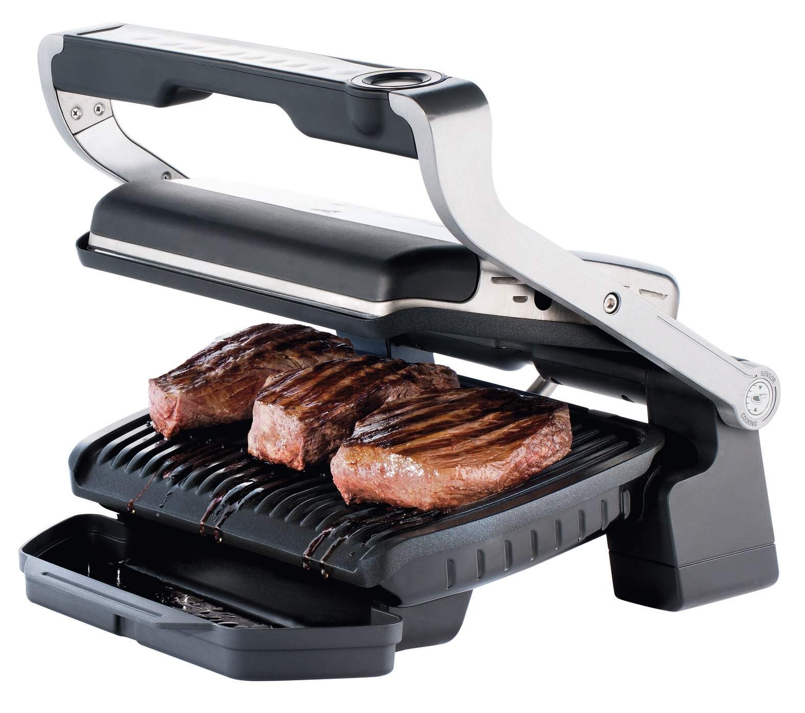Grill z trzema ugotowanymi stekami. Grill jest czarno-srebrny, z tacką ociekową.
