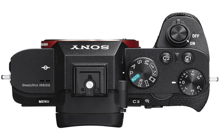 Widok z góry na czarny aparat z przyciskami, pokrętłami i obiektywem, oznaczony napisem 'SONY'.