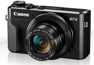 Czarny aparat cyfrowy Canon G7 X. Widoczny obiektyw z zoomem i szczegóły obiektywu Canon Zoom Lens.